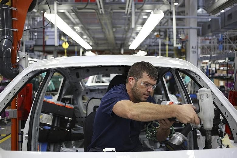 An employee installing interior accessories in a sport utility vehicle on the assembly line at a BMW plant in Greer, South Carolina. The US economy continues to enjoy a strong labour market and low unemployment.