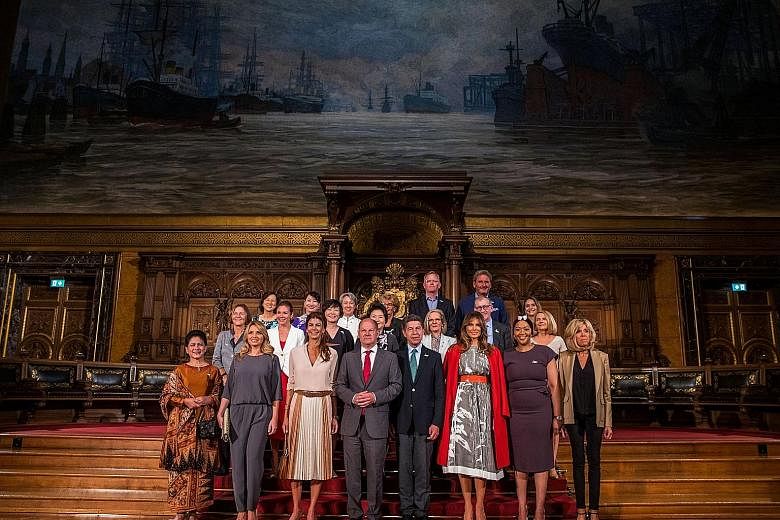 Hamburg Mayor Olaf Scholz (fourth from left) with the partners of G-20 summit participants during a tour of the German city's 17th-century town hall yesterday. With him in the front row are (from far left) Mrs Iriana Widodo, wife of the Indonesian Pr