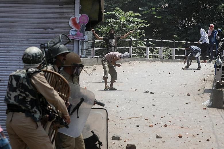 Protesters face off with Indian police and paramilitary soldiers during clashes in Srinagar, the summer capital of Indian-controlled Kashmir, yesterday. Troops were deployed in large numbers to disperse possible protests on the death anniversary of m