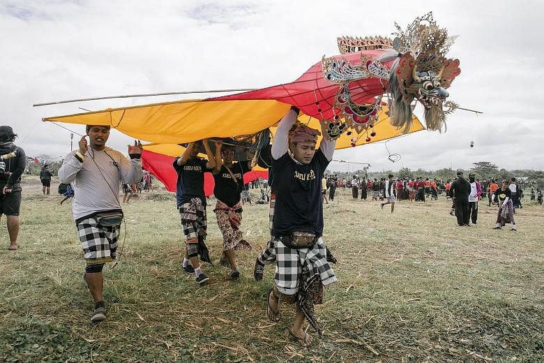Balinese taking part in the annual Bali Kites Festival, a popular tourist event usually held around this time of the year, in Sanur yesterday. Hundreds of rivalling kite troupes from all over the island gather each year to fly their traditional kites