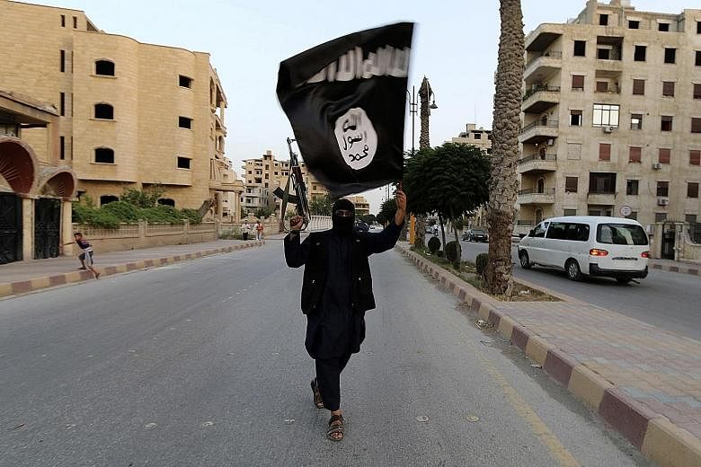 A member of the Islamic State waves the group's flag in Raqqa. Since her son's death on the Syria-Iraq border, the writer has combed through every detail of every memory, searching for clues as to what made him leave home to fight in Syria. The clues