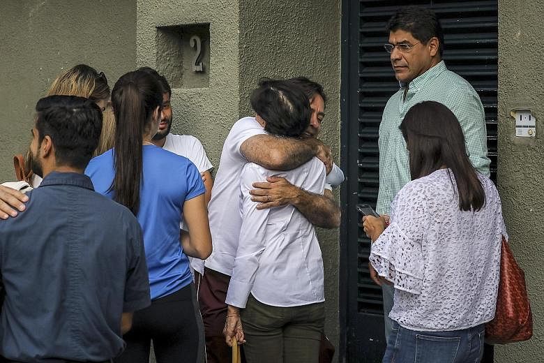 Ms Antonieta de Lopez, the mother of opposition leader Leopoldo Lopez, being hugged by a relative as they wait outside Mr Lopez's residence after he was released from the Ramo Verde military prison and placed under house arrest, in Caracas, Venezuela