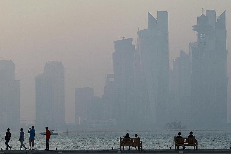 People taking in the skyline in Doha. There has been much speculation that Saudi Arabia, the UAE and Bahrain will seek to push Qatar out of the six-nation Gulf Cooperation Council either through suspension or expulsion.