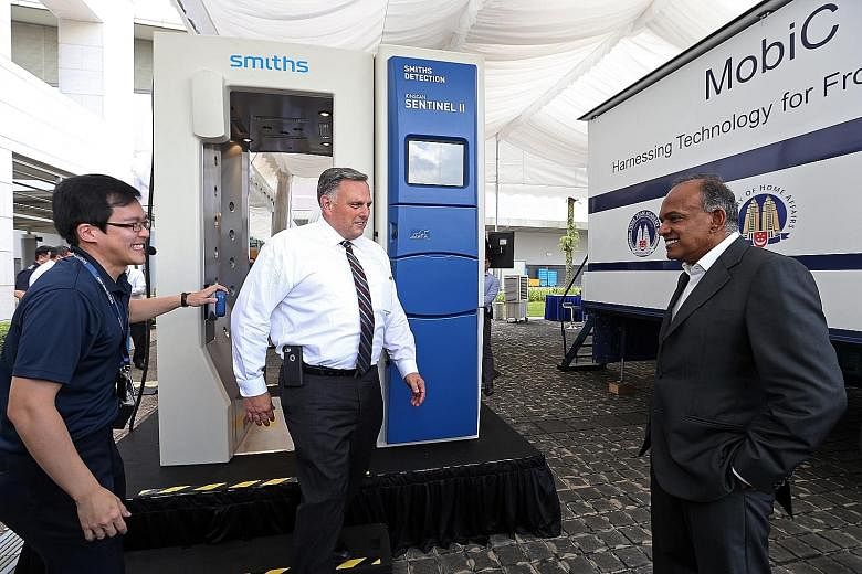 Mr William Bryan, US DHS Under Secretary (Acting) for Science and Technology, trying out the Puffer Portal - a walk-through system that releases puffs of air, dislodging particles on clothing and human bodies to help detect trace amounts of explosive
