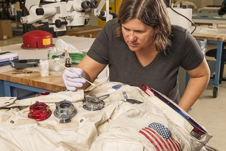 Astronaut Neil Armstrong's spacesuit (above) being worked on in a conservation laboratory; and Dorothy's red slippers from The Wizard Of Oz.