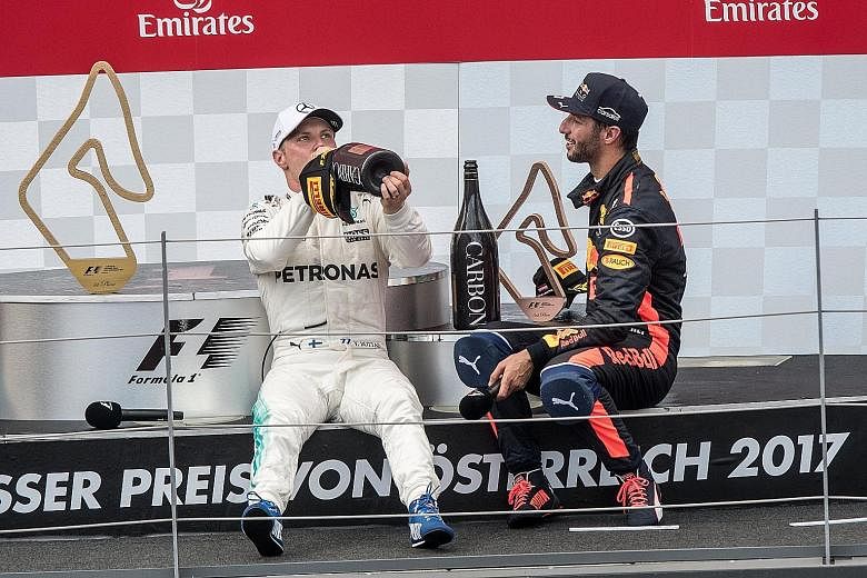Austrian GP victor Valtteri Bottas (left) winding down with Daniel Ricciardo, who came third, over champagne on the podium. The Finn is driving himself into contention for the drivers' championship.