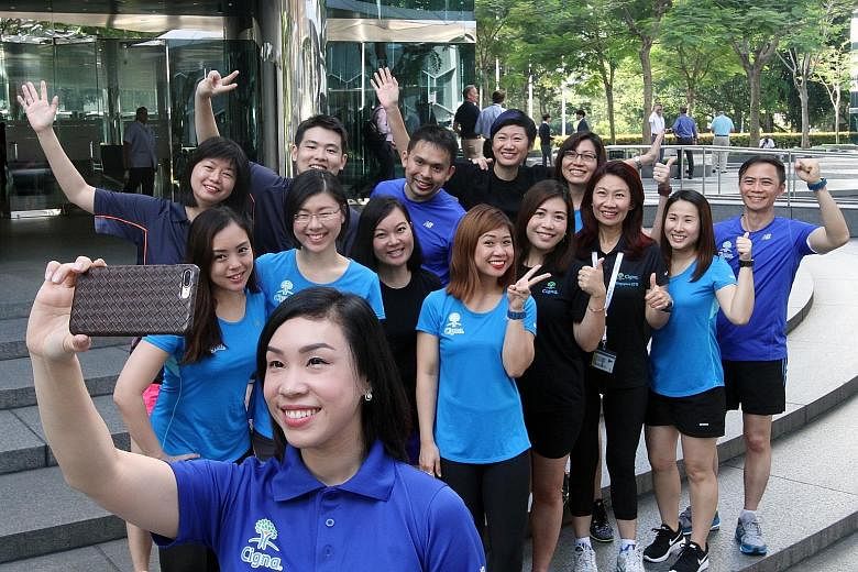 Ms Lena Tsia (third from right), chief executive officer of the Singapore branch of Cigna, which focuses on health insurance, with some of the firm's employees who will be taking part in Sunday's ST Run.