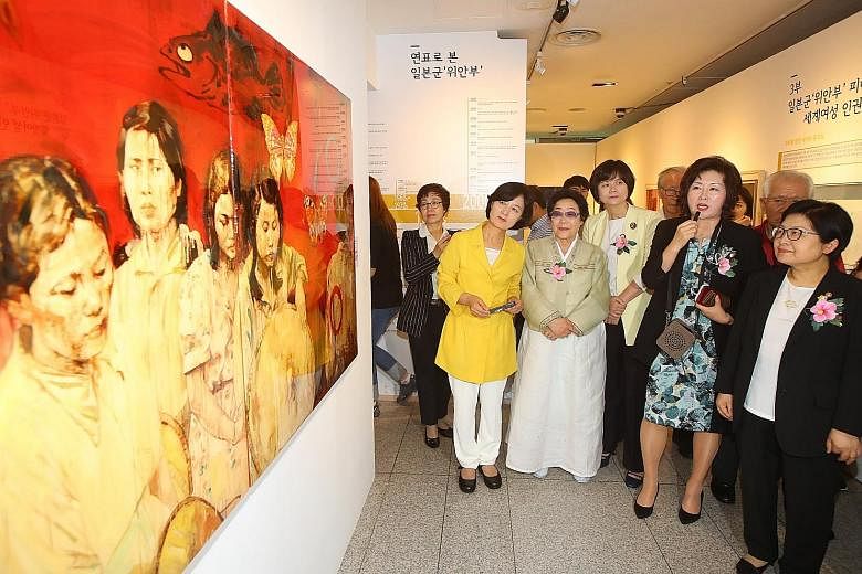 Gender Equality Minister Chung Hyun Back (right) and survivor Lee Yong Soo (third from left) viewing an exhibit on comfort women at the National Museum of Korean Contemporary History in Seoul yesterday. A screen grab from rare footage unearthed last 