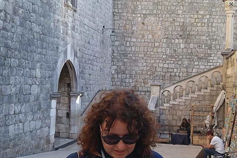Game Of Thrones guide Tonka Matana with a photo of a scene from the drama showing Tyrion Lannister (Peter Dinklage) inside the old city of Dubrovnik.