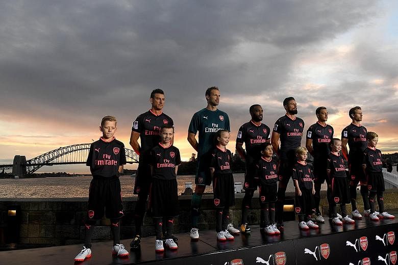 Arsenal players (from left) Laurent Koscielny, Petr Cech, Alexandre Lacazette, Olivier Giroud, Mesut Ozil and Nacho Monreal posing with children as they display the team's third kit at Fort Denison in Sydney. The London side will play Sydney FC and W