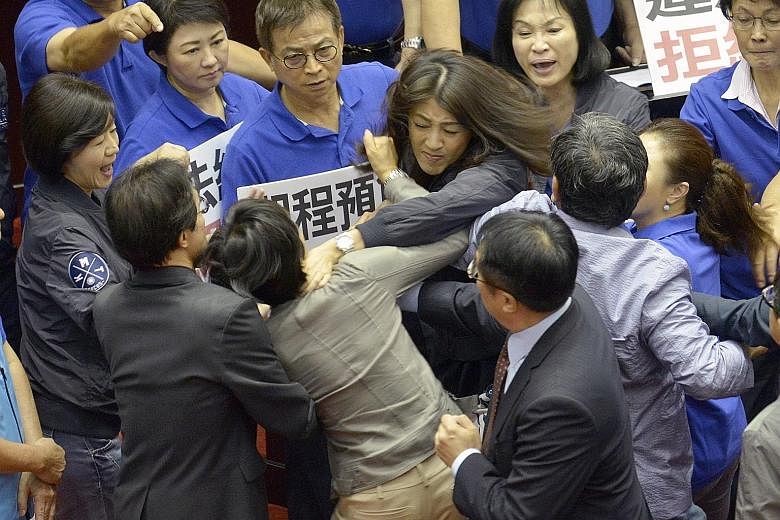 Taiwan's main opposition Kuomintang (KMT) legislator Hsu Shu-hua (centre, facing camera) brawling with ruling Democratic Progressive Party (DPP) lawmaker Chu Yi-ying (in grey, with back to camera) during a review of a major infrastructure project at 