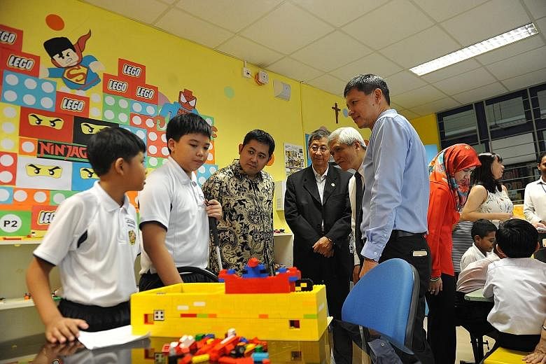 Primary 6 pupils (from left) Mohammad Syahmi Iman Mohammad Shahril and Joshua Babol showing off their creations, which included a lightsaber, in Montfort Junior School's Lego Room and all-new Tinker Room to Prince Abdul Qawi of Brunei (in batik shirt