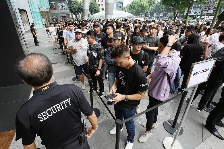 Shoppers wait to enter Louis Vuitton's Ion Orchard boutique yesterday morning.