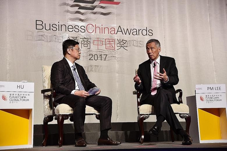 Prime Minister Lee Hsien Loong speaking at the dialogue session of the FutureChina Global Forum yesterday, with moderator Robin Hu, board director of Business China, beside him. On China's Belt and Road initiative, Mr Lee said it is an "open, welcomi