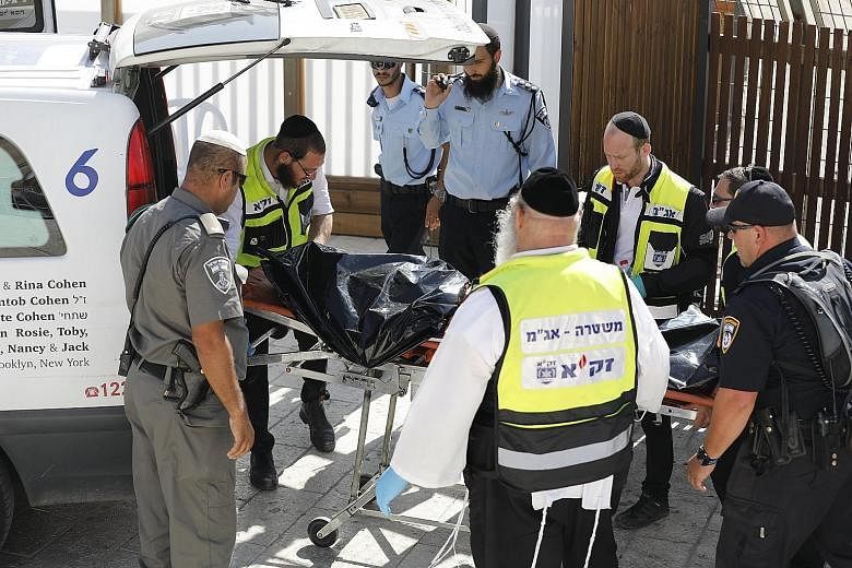 The body of one of the attackers being removed from the Temple Mount compound in Jerusalem's Old City yesterday. It was one of the most serious attacks so close to the volatile holy site in years.