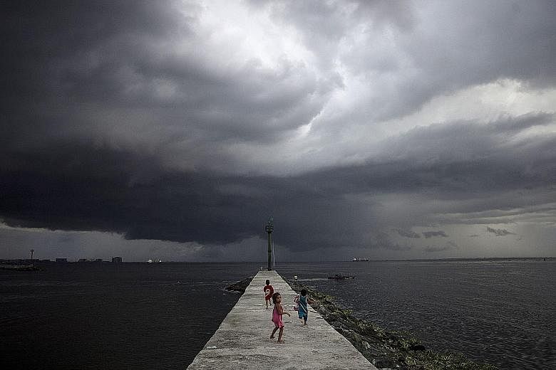 Storm clouds nearing a breakwater in Tondo, the Philippines. The ADB report said Asia is becoming increasingly urban and coastal, placing cities at greater risk from rising sea levels and extreme weather.