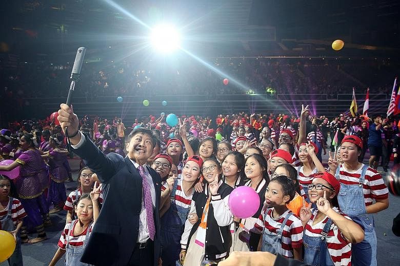 Above: The Singapore contingent at yesterday's march-past. Left: Minister Ng Chee Meng taking a wefie with performers.