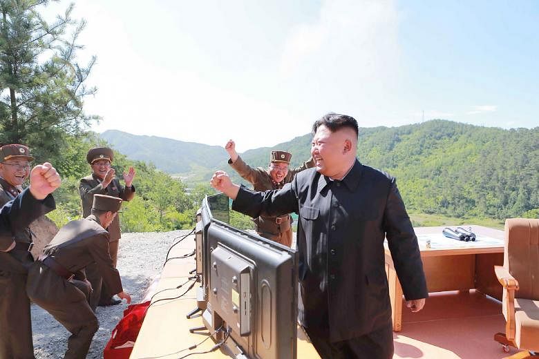 This picture, released on July 4 by North Korea's official Korean Central News Agency, shows North Korean leader Kim Jong Un reacting after the test-fire of the intercontinental ballistic missile Hwasong-14 at an undisclosed location. Mr Kim has repeatedl