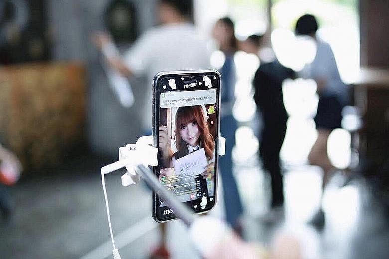 Above: Online host Zhang Xiaoxi starts her day every day in front of her mobile phone talking to hundreds of online viewers, including taking them through her daily routine of putting on make-up. The former model has been doing this full-time for nea