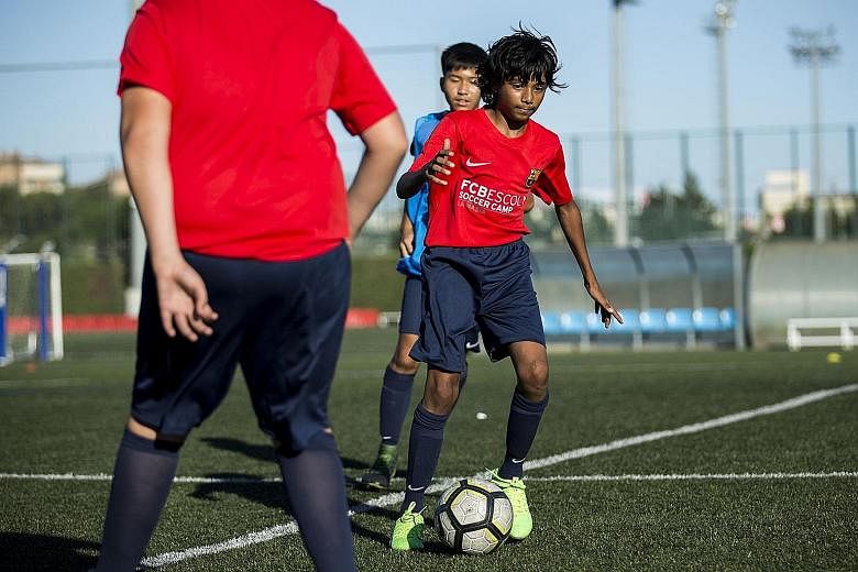 Wayne Lim (above) juggling a ball during the freestyle skills competition at the La Masia academy, while Mohammed Faizaan Shaikh practises during a training session.