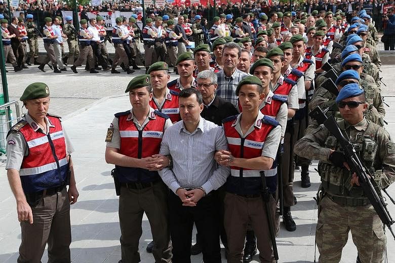 Soldiers accused of being involved in the failed coup being escorted by Turkish soldiers to court in May.
