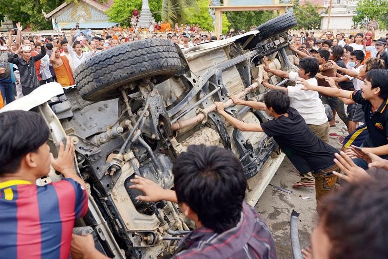 Left: Customers at a gun shop in Manila. Since the mid-1980s, the Philippines has seen two popular-protest movements interspersed with failed military coups. Right: Protesters in Phnom Penh overturning a vehicle in anger over names missing from the v