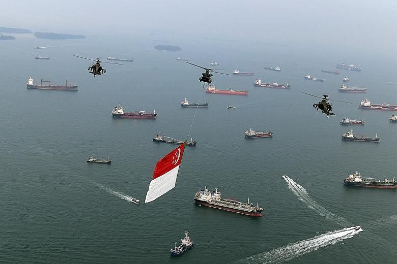 Above: The state flag is flown by a Chinook helicopter and its Apache escorts over the anchorage to the south of the Singapore mainland. Left: Lieutenant- Colonel (Ret) Leo Tin Boon, a former pilot, beside an Alouette III helicopter at the Air Force 