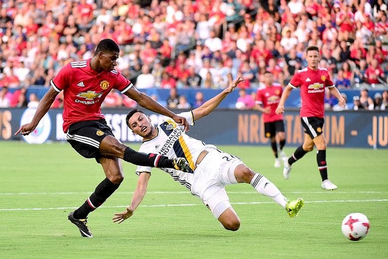 Marcus Rashford getting the better of LA Galaxy's Hugo Arellano to put Manchester United 2-0 up with his second goal. The English team won 5-2.