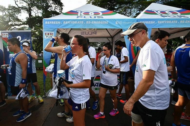 The crowd at the ST Run post-race carnival at the Padang yesterday. Musical acts entertained runners with live performances, while food vendors set up shop to feed the participants and their families and friends. Left: Runners taking photos with a Pi