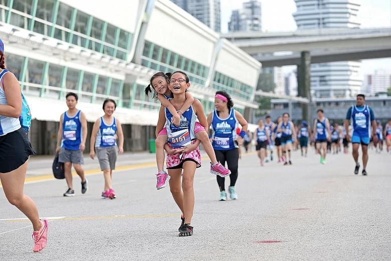 Melody Tan, 10, giving her sister Merrily, five, a piggyback ride during the 5km fun run, which they completed in 55 minutes.
