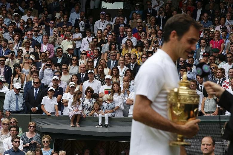 Mirka, the wife of Roger Federer (front row in white), with their children Charlene Riva, Myla Rose, Lenny and Leo in the players' box, as her husband is being interviewed after his eighth Wimbledon victory.