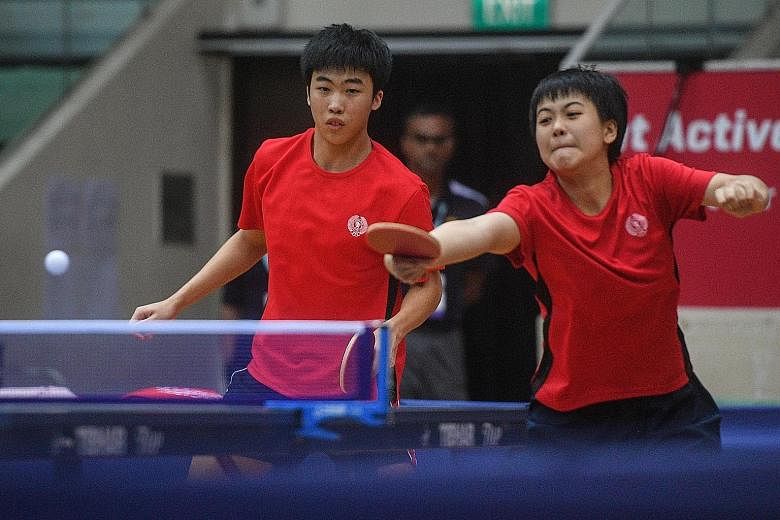 Goi Rui Xuan hits a return during the Asean Schools Games mixed doubles final as her partner Gerald Yu looks on.