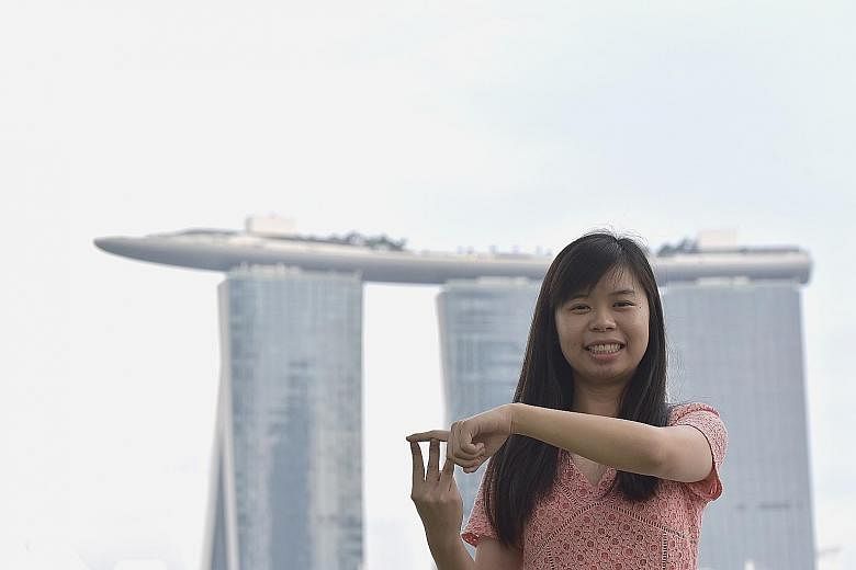 Ms Goh Zhen Yi using sign language to represent Marina Bay Sands. She has long been fascinated by MBS' unique architecture, and spent a year learning sign language so she could use it to represent the iconic landmark. Mr Mohamed Ali Rauff took his mo