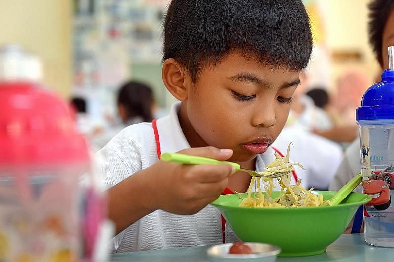 Bedok Green Primary 1 pupil Ziekriy Hannan Khairul Amin eating a bowl of noodles with beansprouts. Under the Healthy Meals in Schools Programme, the school makes sure that vendors serve healthy dishes and limits the sale of snacks.