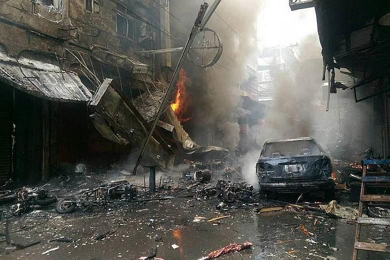 Left: The aftermath of the explosion at a restaurant in the central Taiwan city of Taichung yesterday. The fire also engulfed a clothing store, a noodle eatery, as well as residential units above the shops. Above: Gas cylinders found at the eatery wh