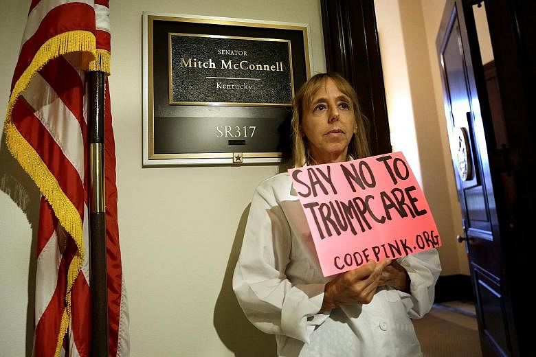 An activist protesting against the Republican healthcare Bill at the Senate on Monday. The Republicans' second attempt to get the Bill passed collapsed as two more senators refused to back it.