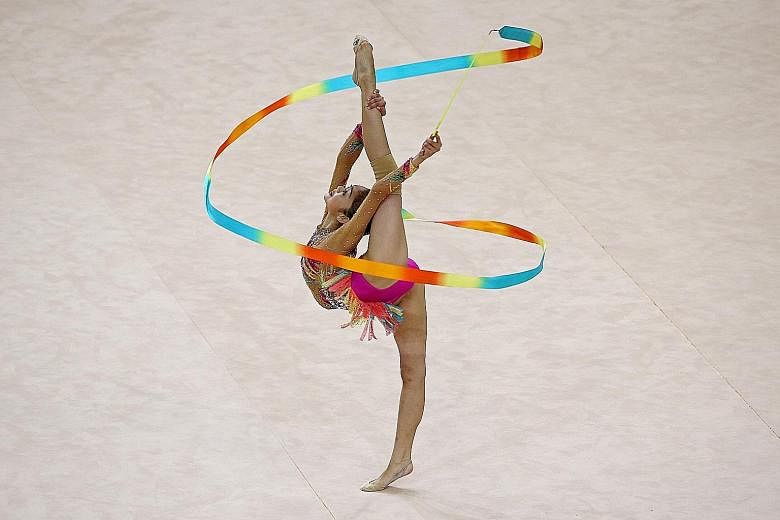 Malaysia's Izzah Amzan performing her ribbon routine at the Bishan Sports Hall. She scored 13.617 points in the final to win gold. The 17-year-old was the star of the Asean Schools Games rhythmic gymnastics competition, winning four golds.