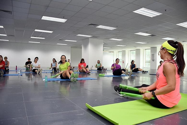 A lunchtime workout at the OUE Downtown building. The Tripartite Oversight Committee on Workplace Health's programmes include health checkups for older workers in hard-to-reach industries, workplace workouts and putting healthier dishes on canteen me