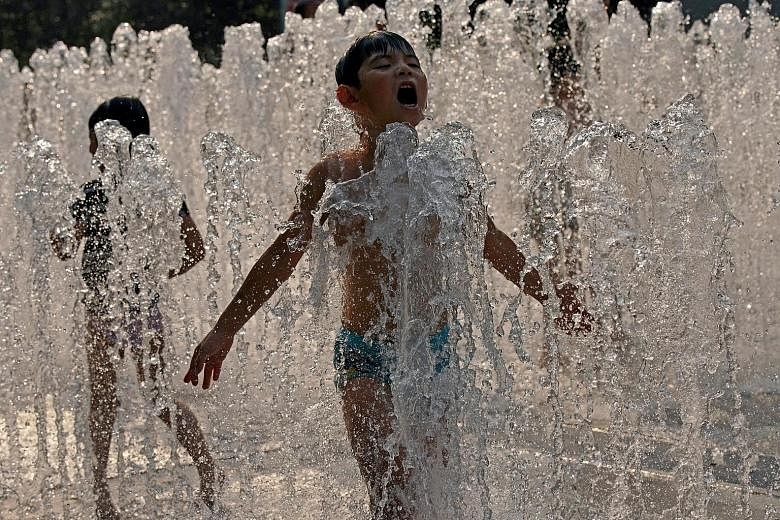 Children cooling off in a fountain in Shanghai yesterday. Shanghai's "red alert" - the first this year - is triggered when temperatures in excess of 40 deg C are forecast.