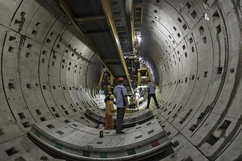 Workers beneath a tunnel-boring machine at a construction site for Line 14 of the Shanghai metro system in China on Tuesday. With a population boom, the city's metro system has roughly doubled in the past decade.