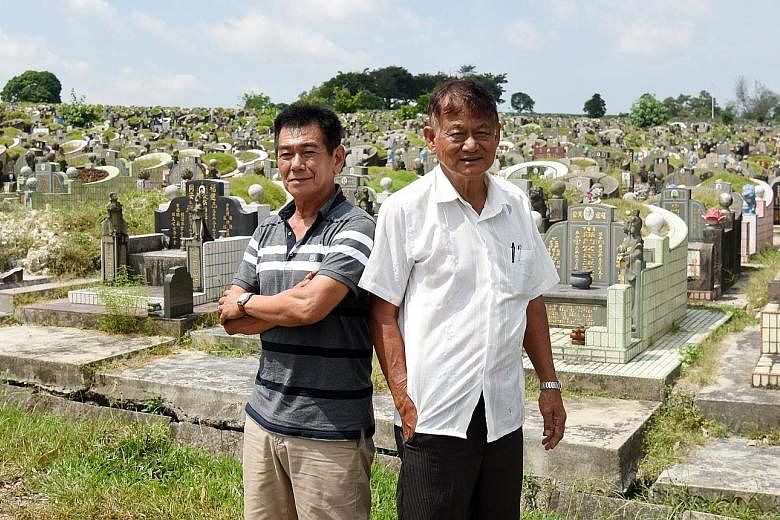 Gravedigger Yow Moom Lam (left) with Mr Johnny Tan of Chua Chu Kang Marble Company. Mr Tan said Mr Yow explains to family members present at an exhumation what each retrieved bone is.