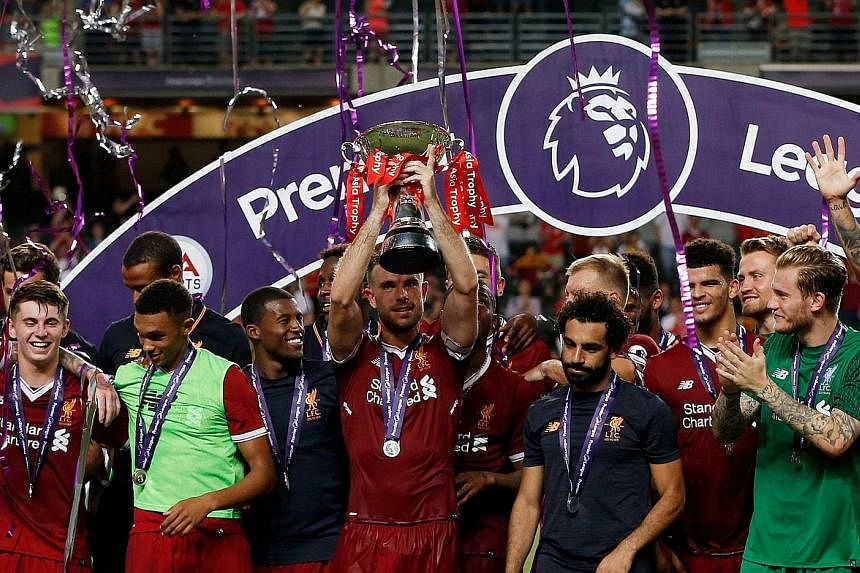 Left: Jurgen Klopp in real life seems like the very opposite of his wild sideline alter-ego - measured, logical and sensible. Below: Liverpool captain Jordan Henderson lifting the Premier League Asia Trophy in Hong Kong. The Reds came from behind to 