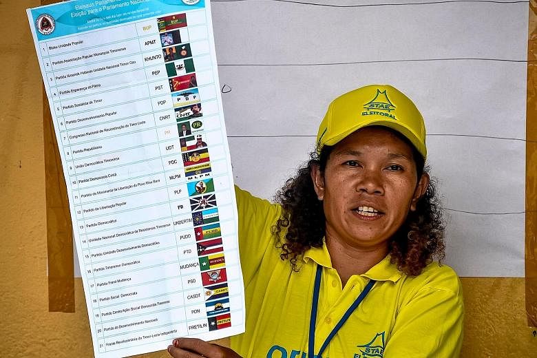 An election official showing a ballot paper in Dili yesterday, as counting begins for the parliamentary elections in Timor Leste.