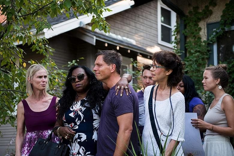 Ms Damond died from a single gunshot wound to the abdomen fired through the open window of a police car. Mr Don Damond, the fiance of shooting victim Justine Damond, being comforted outside his home in Minneapolis by Ms Valerie Castile, whose son Phi