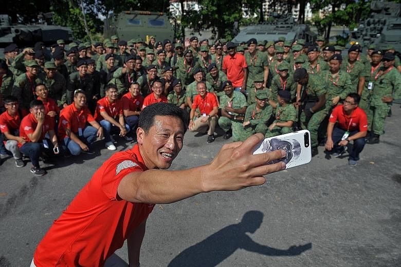 Mr Ong Ye Kung taking a wefie with the participants of the Dynamic Defence Display at the F1 Village yesterday. The minister was visiting NDP participants and staff at the preview show, during which he said that The Float @ Marina Bay has been one of