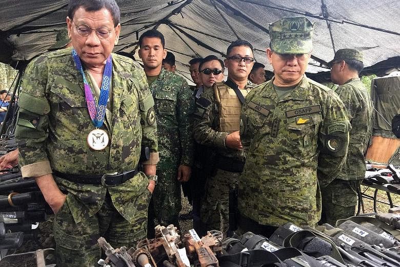 Philippine President Rodrigo Duterte examining seized weaponry from militants in Marawi last Thursday.