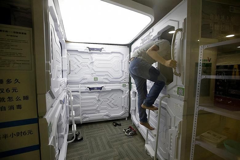 A man entering a capsule bed unit in Beijing. Each napping pod is equipped with an electric fan, reading light and USB port. Users get a disposable bedsheet, pillow cover and blanket before they enter the capsule.