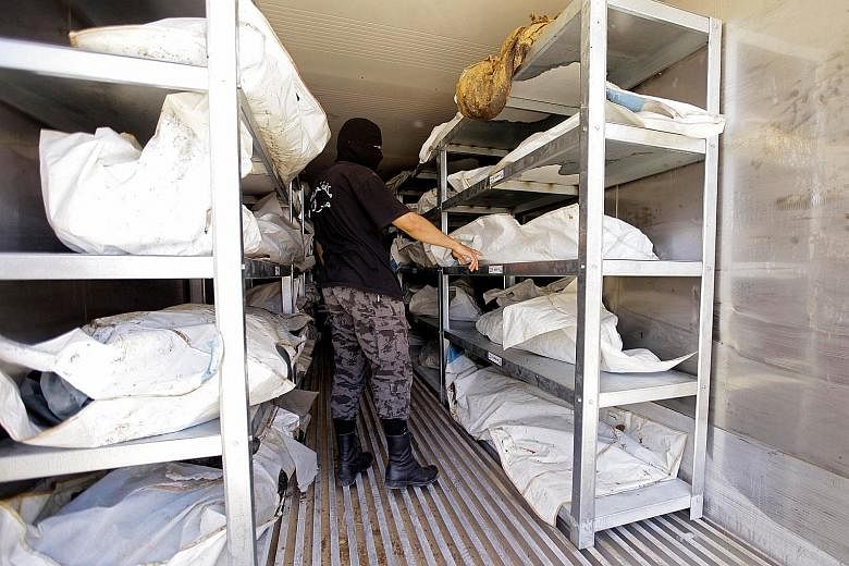 A member of Libya's anti-crime service in a morgue in Misrata where the bodies of foreign ISIS militants are stored. Hundreds of bodies foreign militants still lie in freezers as the authorities negotiate with other governments to decide what to do w