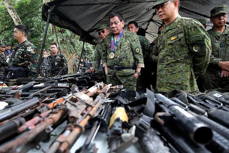 President Rodrigo Duterte (centre) inspecting firearms at a military camp in Marawi City.