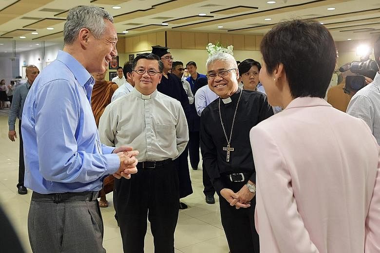Prime Minister Lee Hsien Loong chatting with Monsignor Philip Heng (second from left), vicar-general (interreligious relations) of the Archdiocesan Catholic Council for Interreligious Dialogue; Roman Catholic Archbishop William Goh; and Minister for 